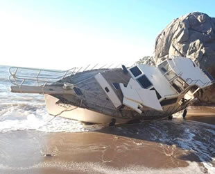 Antalya’da halatı kopan tekne, kıyıya vurup yan yattı