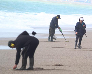 Dev dalgalar eşliğinde sahilde define aradılar