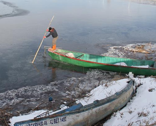 Balıkçılar, donan gölde buz tabakasını kırıp avlanmaya çıkıyor