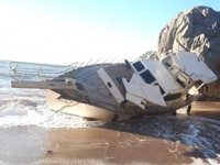Antalya’da halatı kopan tekne, kıyıya vurup yan yattı